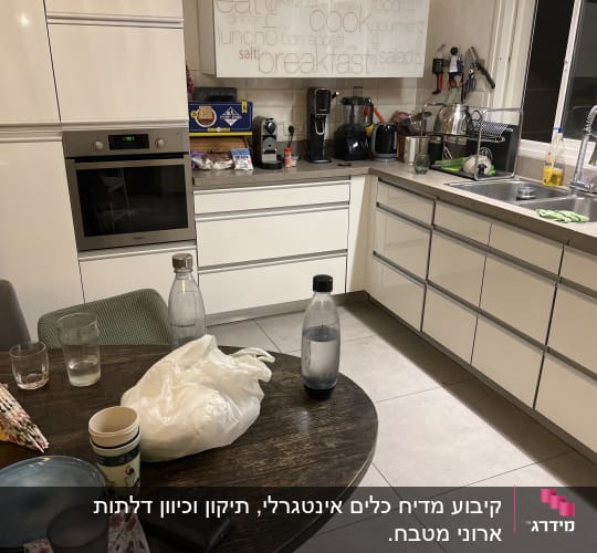 מטבח עם תנור, כיור וכלים על השיש